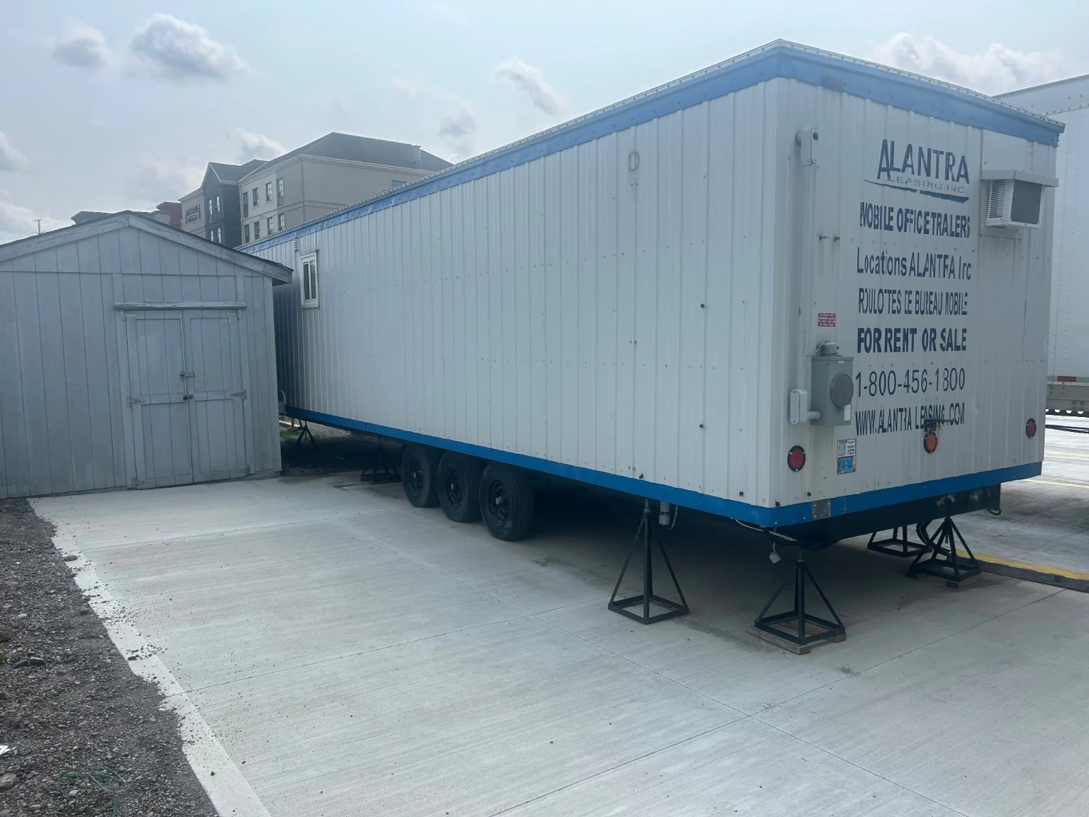 Concrete trailer support surface beneath parked semi-trailer landing gear